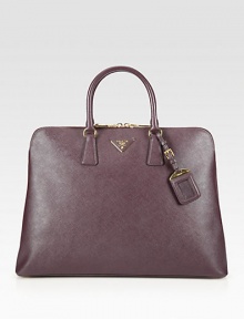Roomy carryall with a structured frame in saffiano lux leather.Double top handles, 4¾ dropTop zip closureProtective metal feetOne inside zip compartmentOne inside zip pocketThree inside open pocketsSignature jacquard lining16W X 11¾H X 6DMade in Italy Roomy carryall with a structured frame in saffiano lux leather.Double top handles, 4¾ dropTop zip closureProtective metal feetOne inside zip compartmentOne inside zip pocketThree inside open pocketsSignature jacquard lining16W X 11¾H X 6DMade in Italy