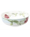 Painterly lilies bloom in and around this porcelain bowl, creating a beautiful arrangement with the rest of Oleg Cassini's Sweet Blossom dinnerware.