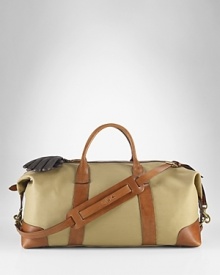 An ideal size for travel, this heritage duffle is rendered in durable cotton twill with glossy leather accents and a removable webbed shoulder strap for versatile on-the-go styling. An ideal size for travel, this heritage duffle is rendered in durable cotton twill with glossy leather accents and a removable webbed shoulder strap for versatile on-the-go styling.