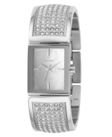 Knockout style by DKNY. This watch features a crystal-accented stainless steel half-bangle bracelet and rectangular stainless steel case. Mother-of-pearl dial with silvertone stick indices and logo. Quartz movement. Water resistant to 30 meters. Two-year limited warranty. Knockout style by DKNY. This watch features a crystal-accented stainless steel half-bangle bracelet and rectangular stainless steel case. Mother-of-pearl dial with silvertone stick indices and logo. Quartz movement. Water resistant to 30 meters. Two-year limited warranty.