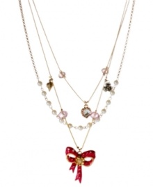 Understated appeal. This three-row necklace from Betsey Johnson is crafted from antique gold-tone mixed metal with glass pearl accents and pink beads adorning the chains. A fuchsia bow in the center ties it all together. Item comes packaged in a signature Betsey Johnson Gift Box. Approximate length: 16 inches + 3-row extender. Approximate drop: 2-3/4 inches.