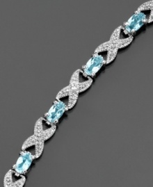 A unique setting for December's birthstone, this stylish bracelet by Victoria Townsend features oval-cut blue topaz (3 ct. t.w.) and diamond accents set in sterling silver. Approximate length: 7-1/4 inches.