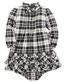 A traditional, festive plaid is constructed with a pintucked front and a flurry of ruffle trim along the neck and hem. A traditional, festive plaid is constructed with a pintucked front and a flurry of ruffle trim along the neck and hem.