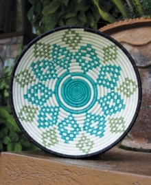 Inspired by trees, the handcrafted Imbaho basket is woven with a serene leaf pattern symbolic of stability and growth. A green, black and turquoise palette contrasts natural sisal in a piece that serves as fruit bowl, wall art or table centerpiece.